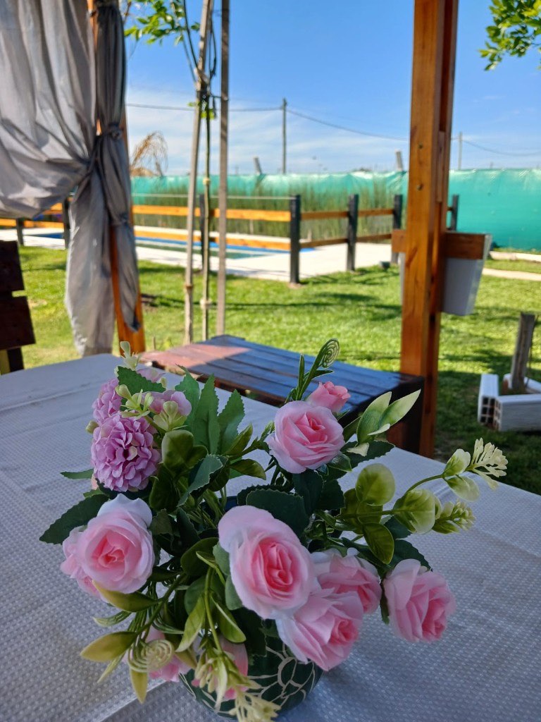 Flores sobre la mesa, con la quinta detrás